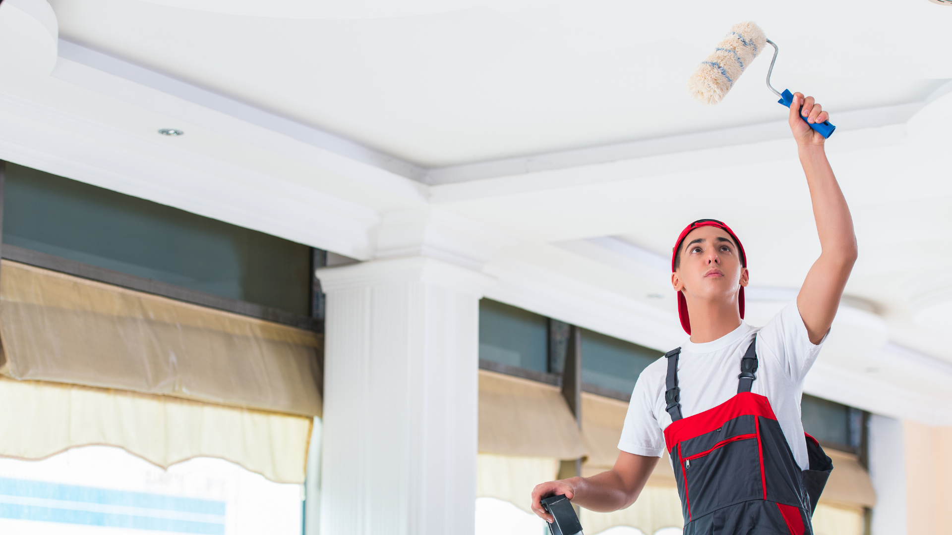 Young waterproofer applying a roller coat during a roof waterproofing job